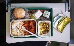 Airplane food, rice and chicken meat with beans salad, on tray table